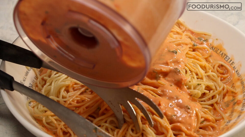pouring the cream over the pasta