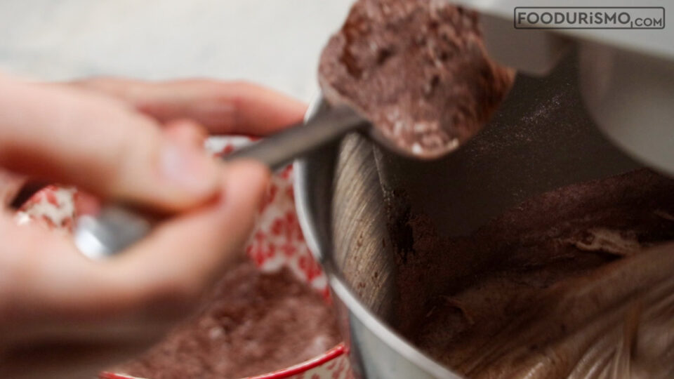 Προσθέτουμε κουταλιά κουταλιά το αλεύρι και το κακάο στο μείγμα των αυγών